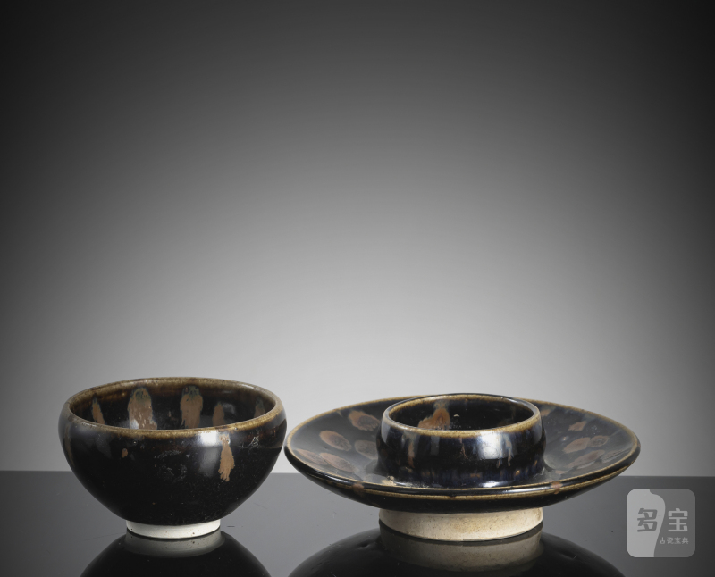 A black-glazed russet-splashed tea bowl on an associated base